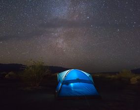 Ярко-синяя туристическая палатка освещена изнутри в поле под впечатляющим, усыпанным звездами небом с видимым Млечным Путем.